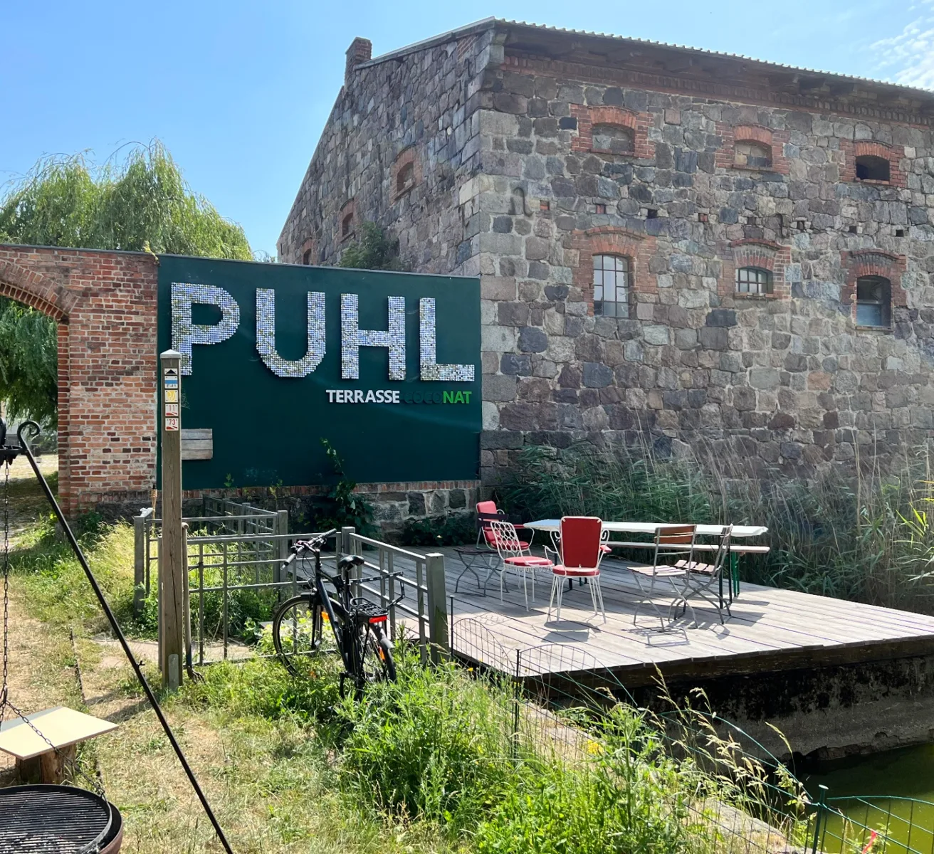 Coconat bei Bad Belzig – altes Steinhaus mit Holzterrasse am Wasser.